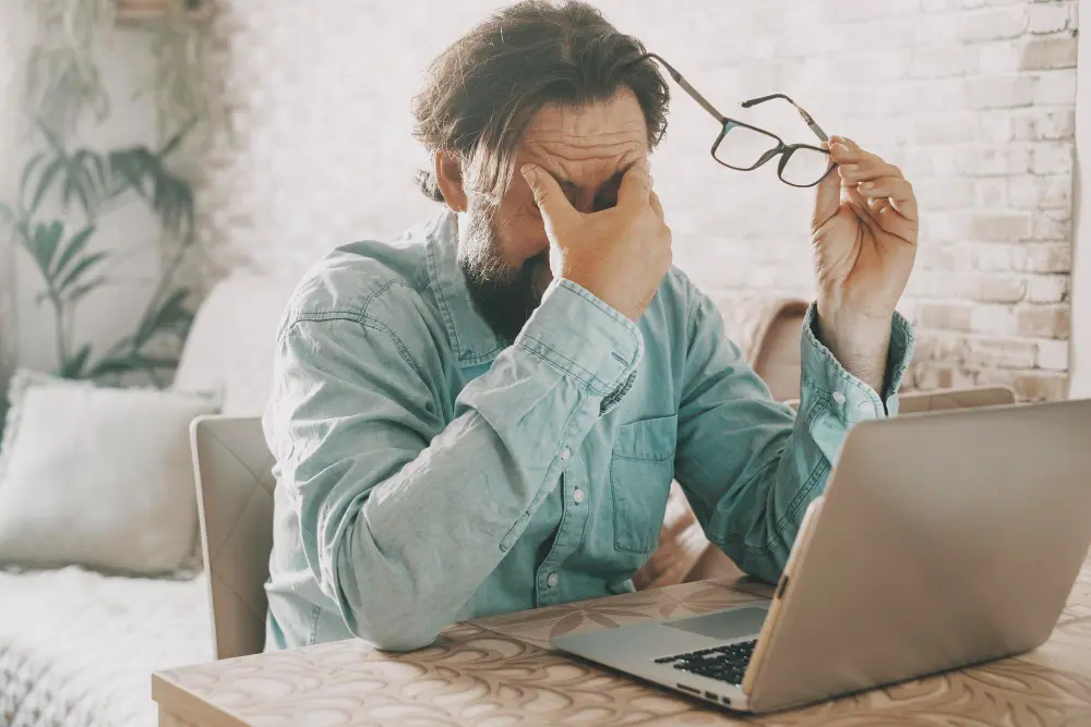 Hombre con cansancio visual después de trabajar con el ordenador
