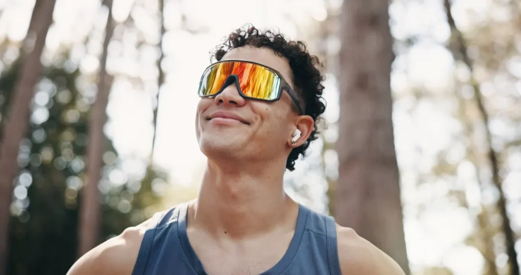 Joven con gafas de sol deportivas de lente espejada en el exterior