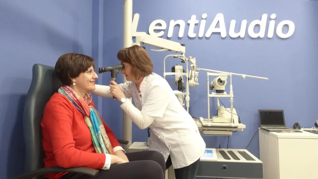 Óptica-optometrista examinando el ojo de una paciente en LentiAudio Montijo