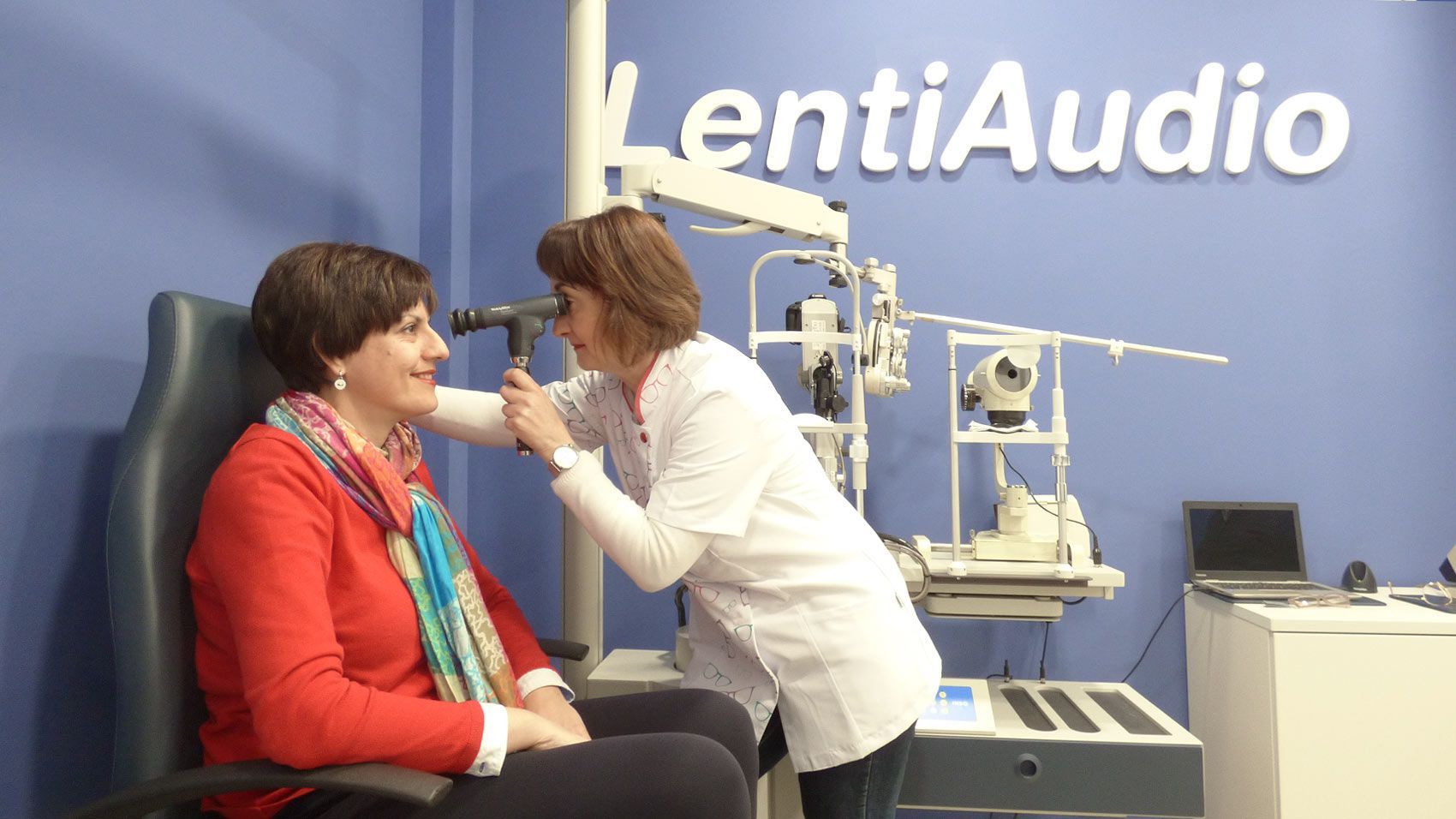 Óptica-optometrista examinando el ojo de una paciente en LentiAudio Montijo